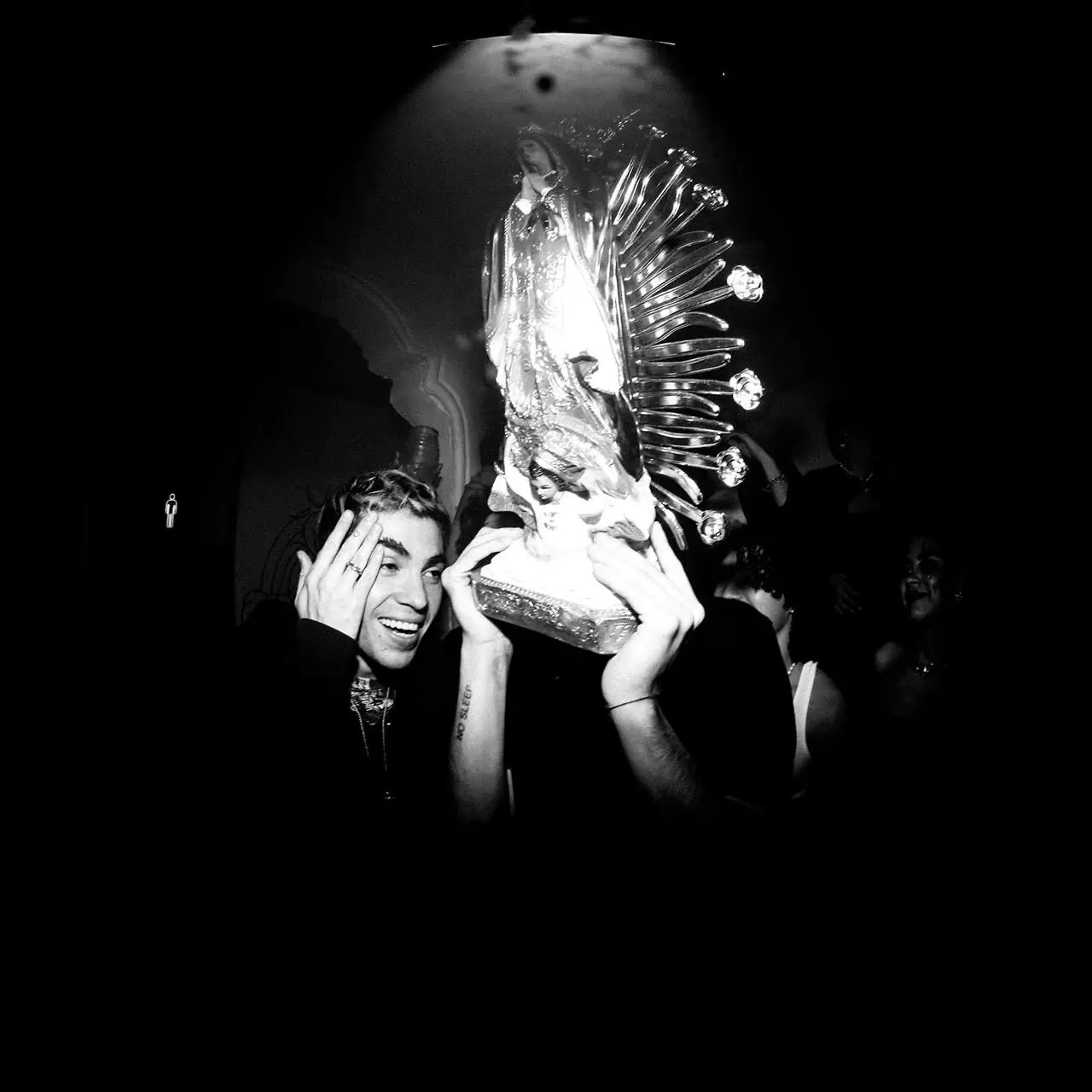 Chico sosteniendo una figura de la Virgen de cristal